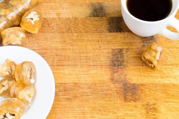 Lokum tradizionale delizia turca con vista dall'alto di nocciole. Dessert arabo dolce e tazza di caffè nero su fondo di legno