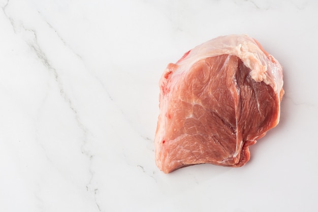 Lombo di maiale di carne, maiale, fette su uno sfondo bianco. Carne suina cruda. Pubblicità per macelleria e fattoria. Vari tipi di carne e concetto pronto da cucinare. Vista dall'alto. Spazio per il testo