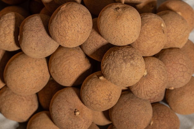 Longan essiccato nel contenitore sul tavolo con venature del legno