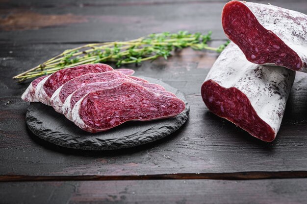 Longaniza, salsiccia tradizionale stagionata tagliata a fette sul tavolo di legno scuro