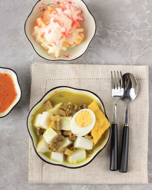 Lontong Kari Sapi o curry di manzo indonesiano con torta di riso. Cibo di strada Popolare per la colazione a West Java, Indonesia