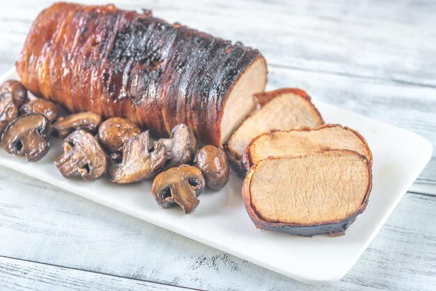 Lonza di maiale avvolta in pancetta con funghi arrostiti