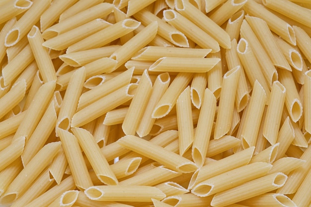 Lotto di penne di pasta Trama di maccheroni secchi Sfondo di cibo