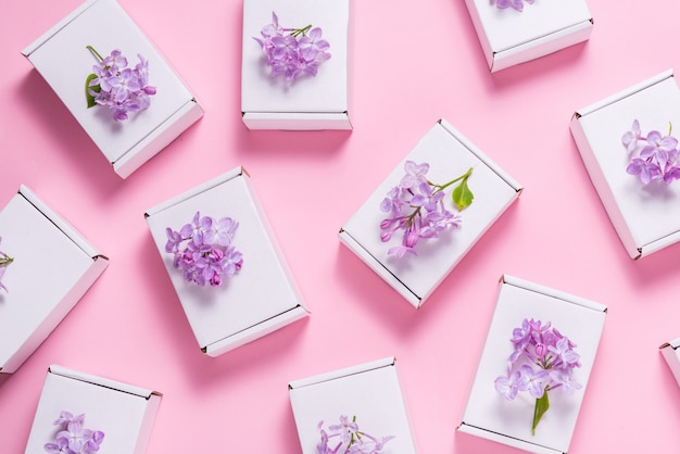 Lotto di scatole regalo decorate con fiori lilla su sfondo rosa