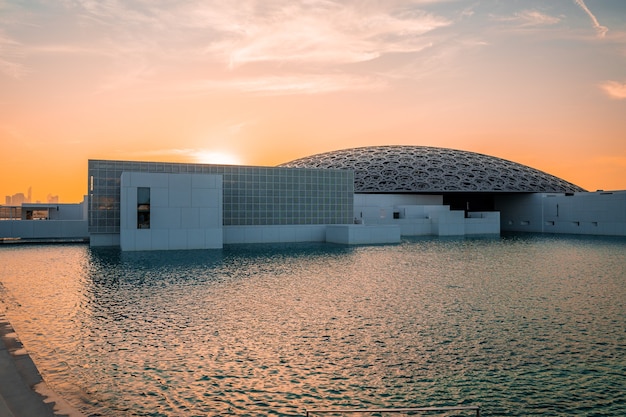 Louvre, Abu Dhabi, Emirati Arabi Uniti - 10 maggio 2020. Il famoso museo del Louvre dell'architetto francese Jean Nouvel - vista panoramica dalla tribuna al tramonto.