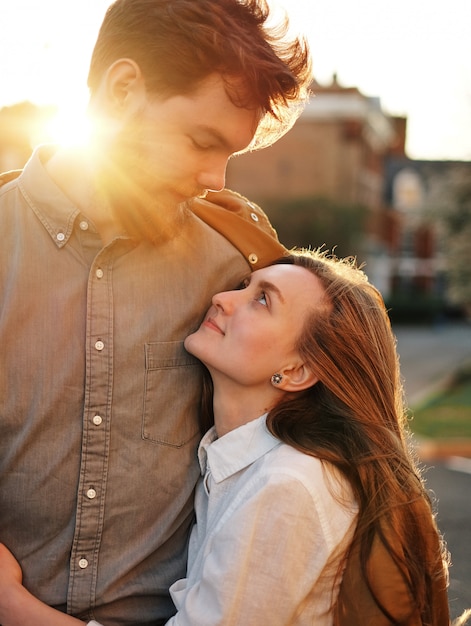 love guy vuole baciare la sua ragazza, guardandolo negli occhi, al tramonto, all&#39;aperto, i raggi del sole