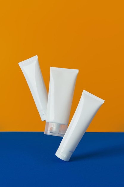 Lozione o crema su sfondo arancione e blu trattamento di bellezza per la cura del corpo del viso