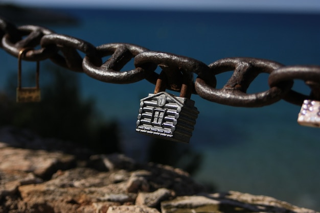 lucchetto a forma di casa su una catena in riva al mare