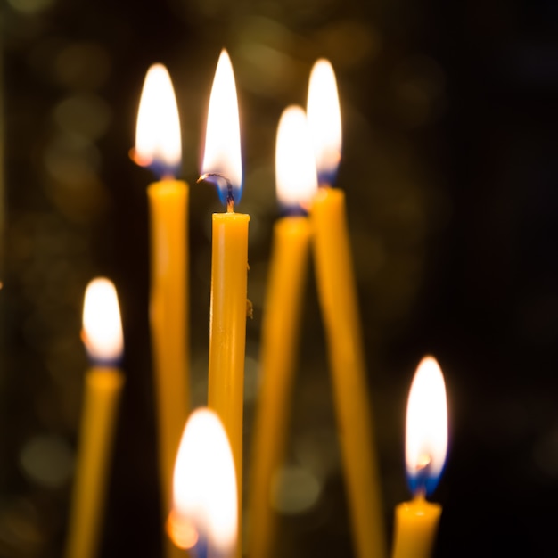 Luce di candele in chiesa con sfondo scuro
