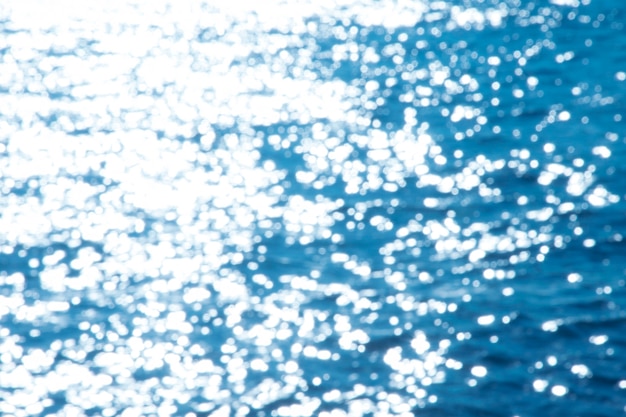 Luce di riflessione sulle luci astratte defocused del mare blu.