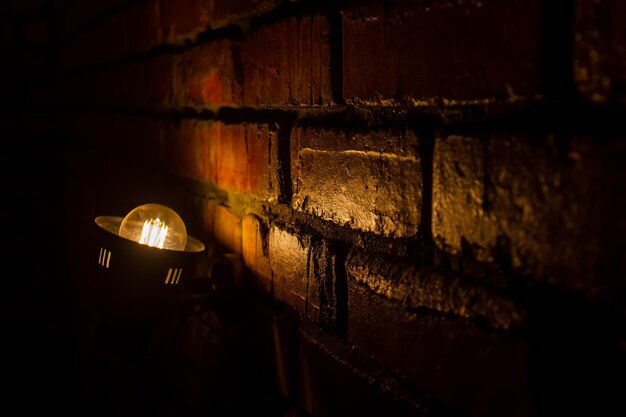 luce nel buio vecchia lampada sul muro vecchia parete di mattoni con luce