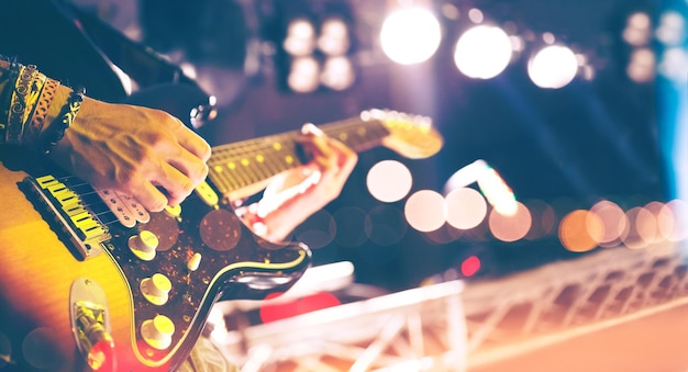 Luci da palcoscenicoSfondo musicale astrattoSuonare la chitarra e il concetto di concerto