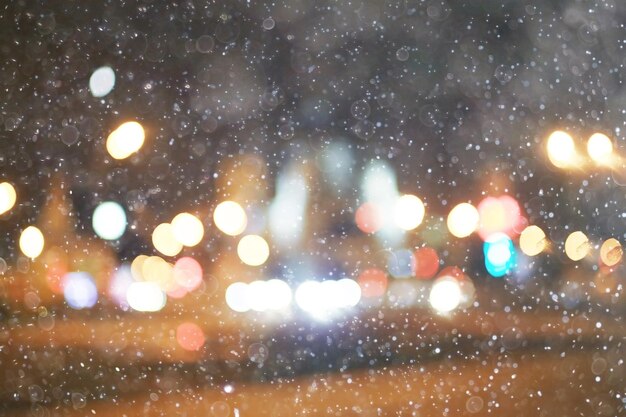 luci della città bagliore di neve sfondo sfocato / paesaggio urbano sfocato bokeh, tempo nevoso sfondo stagionale inverno dicembre