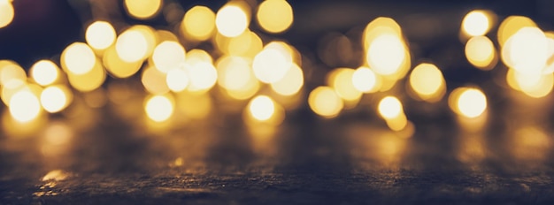 Luci di Natale con effetto bokeh dorato su sfondo nero con spazio per la copia. ideale per layout di siti web e riviste