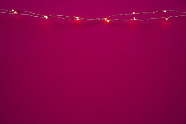 Luci ghirlande illuminate su sfondo rosa brillante