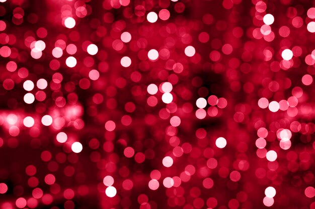 Luci incandescenti sfocate di ghirlande di rosso porpora rosa tonalità colore bokeh tonico in viva magenta colore di tendenza dell'anno 2023
