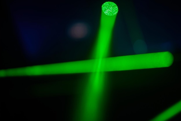 Luci laser al neon verde brillante illuminano l'oscurità creando linee e forme triangolari in scifi e...