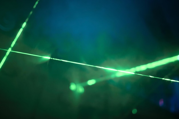 Luci laser al neon verde brillante illuminano l'oscurità creando linee