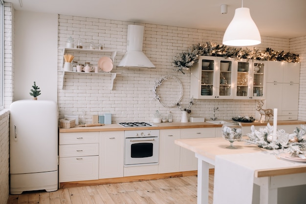 Luminosa e moderna cucina-sala da pranzo con decorazioni natalizie. Foto per la pubblicità con spazio per il testo