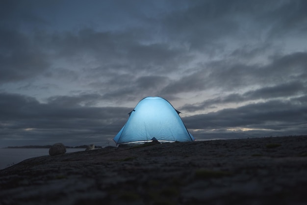 Luminosa tenda turistica sullo sfondo del cielo serale Il tema delle escursioni e delle attività all'aperto