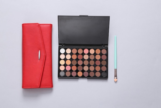 Luminoso make up eye shadow pallete e borsa su sfondo grigio Beauty still life Vista dall'alto