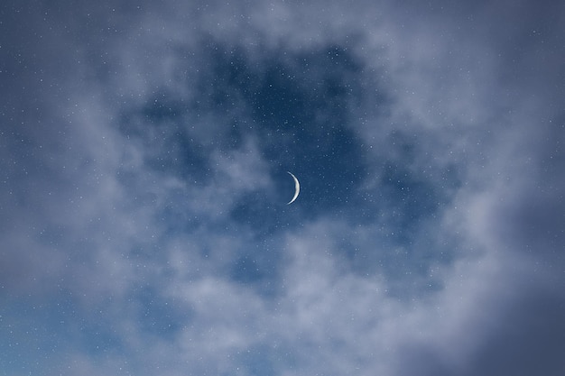 Luna crescente nel cielo blu con nuvole bianche