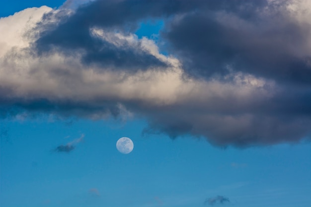 Luna piena su cielo blu con nuvole