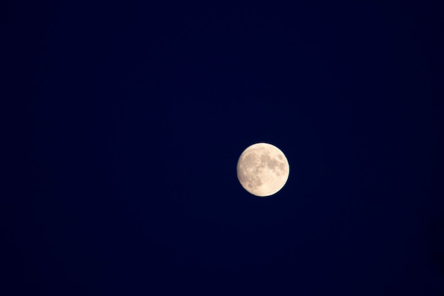 Luna piena su uno sfondo di cielo azzurro