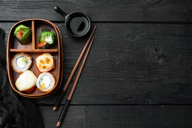 Lunch box bento giapponese con set di bacchette, sul tavolo di legno nero