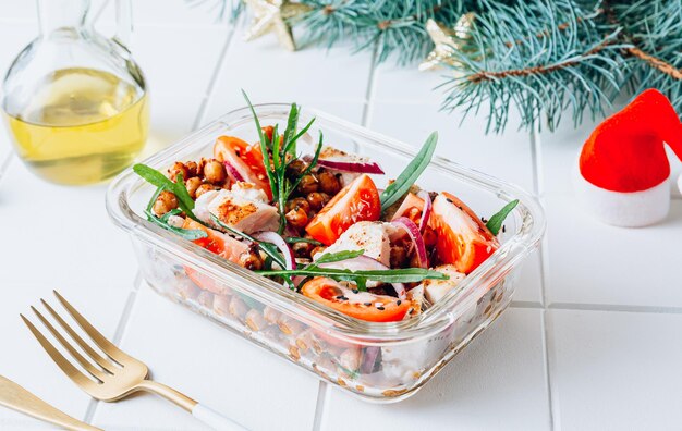 Lunch box con insalata tiepida con pollo alla griglia ceci piccanti pomodoro e rucola