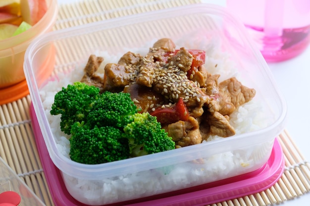 Lunch box in stile asiatico con carne di maiale al sesamo e broccoli