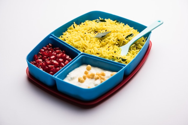 Lunch Box o Tiffin per bambini indiani, contiene riso al limone, nahi-boondi e melograno o Anar. messa a fuoco selettiva