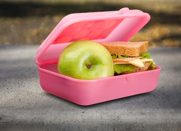 Lunchbox con una mela e un panino sul tavolo