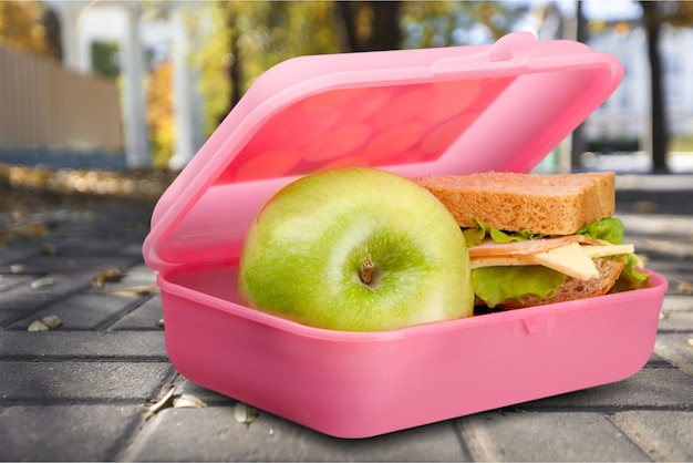 Lunchbox con una mela e un panino sul tavolo