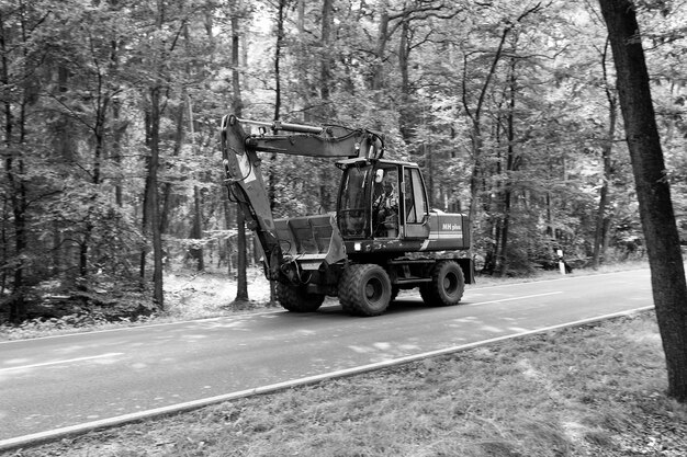 Luneburg Germania 22 agosto 2014 escavatore rosso pesante o attrezzatura per escavatore per la costruzione e lavori di sterro con azionamenti di pala lungo la strada su sfondo naturale