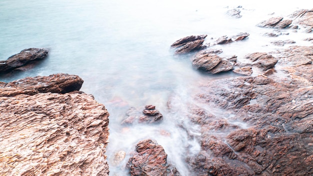 Lunga esposizione del mare con onde lisce e paesaggio roccioso Natura del periodo delle vacanze di Seascape per vacanze rilassanti