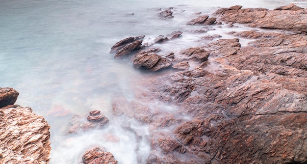 Lunga esposizione del mare con onde lisce e paesaggio roccioso Natura del periodo delle vacanze di Seascape per vacanze rilassanti