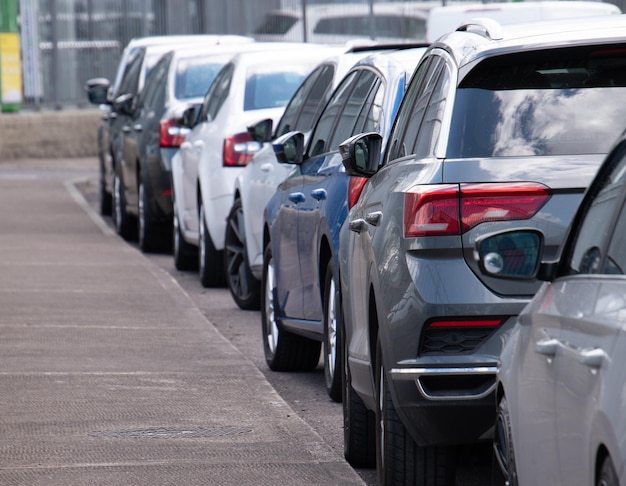 Lunga fila di auto parcheggiate in un quartiere tranquillo su una strada vuota e pulita.