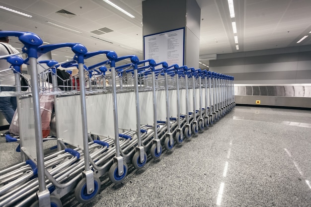 Lunga fila di carrelli portabagagli al terminal dell'aeroporto