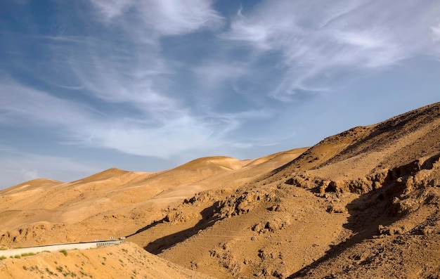 Lunga strada di montagna vuota verso la grande montagna Sodoma Gomorra Strada verso la grande montagna nel Mar Morto dal deserto del Negev Israele Le montagne di Sodoma situate sul lato sud-ovest del Mar Morto