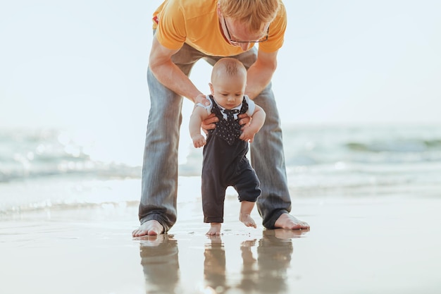 Lunghezza completa di padre e figlio sulla riva del mare