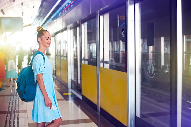 Lunghezza completa di una donna in piedi sulla finestra del treno