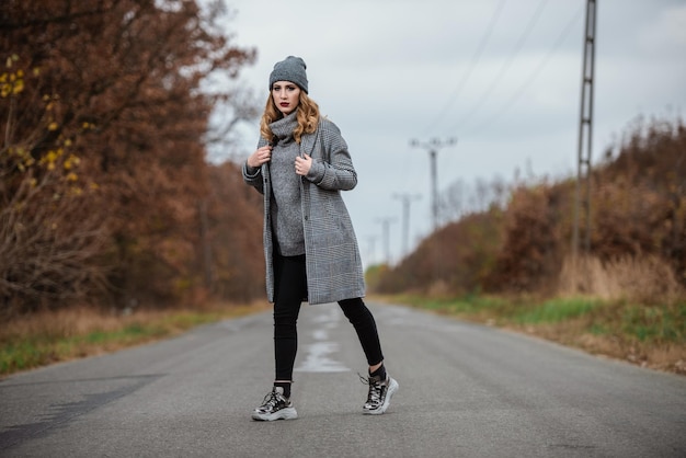 Lunghezza completa di una donna in piedi sulla strada in inverno