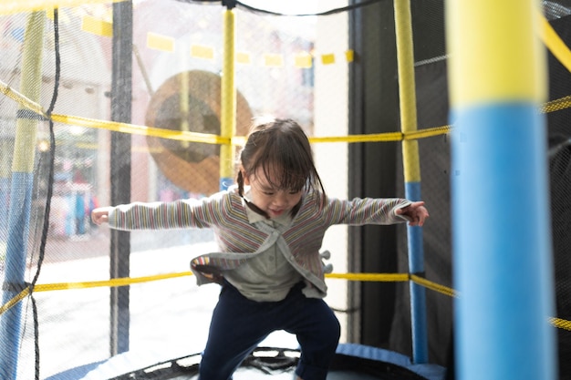 Lunghezza completa di una ragazza che gioca sul trampolino