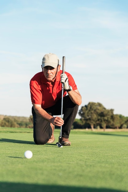 Lunghezza intera di un uomo con la palla sul campo da golf