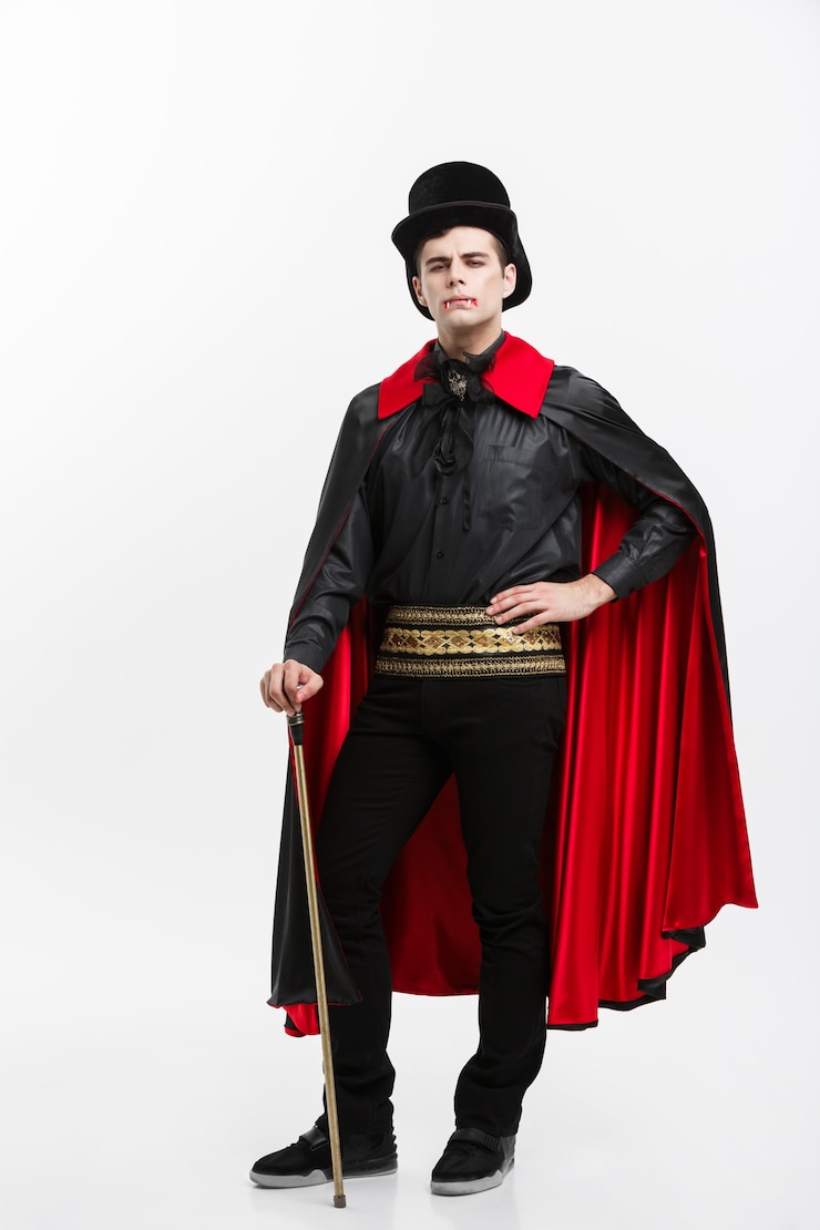 Foto lunghezza ritratto di bel vampiro caucasico in costume di halloween nero e rosso.