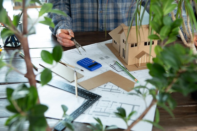 Luogo di lavoro dei disegni costruttivi dell'architetto modello in scala e strumenti Concetto immobiliare di design moderno per la casa