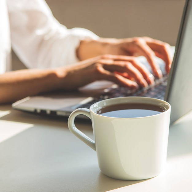 Luogo di lavoro moderno con il computer portatile nell'ombra.