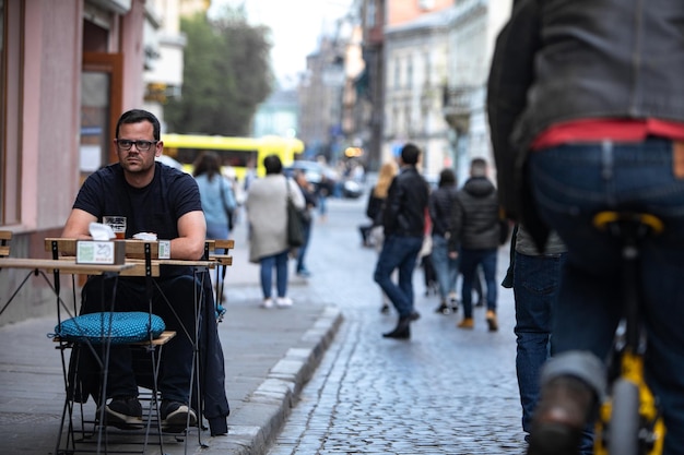 LVIV UCRAINA 25 aprile 2019 uomo che beve birra al bar della strada della città