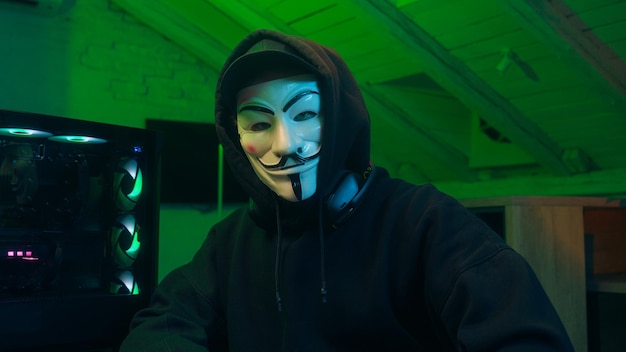 Lviv Ucraina giugno uomo in maschera che usa il telefono cellulare smartphone anonimo guardando la tecnologia della telecamera